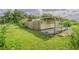 A large, grassy backyard featuring a weathered fence and covered storage structure at 3505 Medulla Rd, Plant City, FL 33566