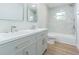 This bright bathroom offers a double vanity with a stylish sink and faucet, a tub, and sleek marble tile at 3505 Medulla Rd, Plant City, FL 33566