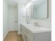 This bathroom offers double vanity sinks with new faucets, storage space, mirrors, and wood-look floors at 3505 Medulla Rd, Plant City, FL 33566