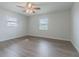 Bright bedroom featuring sleek modern wood floors, ceiling fan and lots of natural light from the two windows at 3505 Medulla Rd, Plant City, FL 33566