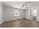 This cozy bedroom features hardwood floors, a ceiling fan, a closet, and natural light through a window at 3505 Medulla Rd, Plant City, FL 33566