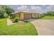 This home features a driveway, attached garage, brick facade, metal roof, and manicured lawn at 3505 Medulla Rd, Plant City, FL 33566