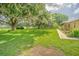 Expansive front yard with mature trees and lush lawn surrounding a charming home at 3505 Medulla Rd, Plant City, FL 33566