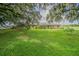 Charming brick home with lush, green front yard, mature trees, and metal roof at 3505 Medulla Rd, Plant City, FL 33566