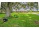 Spacious front yard with mature trees and a tree swing, leading to a brick home at 3505 Medulla Rd, Plant City, FL 33566