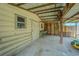 Covered storage area with concrete flooring and side door, offering ample space for projects and equipment at 3505 Medulla Rd, Plant City, FL 33566