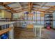 Well-lit shed interior with wood flooring, shelving, storage space, and work tables at 3505 Medulla Rd, Plant City, FL 33566