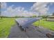 Long row of solar panels for renewable energy, set within a grassy field at 3505 Medulla Rd, Plant City, FL 33566