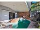 Indoor pool surrounded by brickwork, and sliding doors accessing the outside area at 4173 85Th N St, St Petersburg, FL 33709