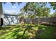 Spacious backyard with lush green grass, shade trees, wooden privacy fence, and storage shed at 4637 4Th N Ave, St Petersburg, FL 33713