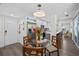 Bright dining area with glass table, modern light fixture, stainless steel refrigerator and white cabinets at 4637 4Th N Ave, St Petersburg, FL 33713