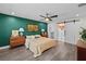 Bright main bedroom with en suite bathroom featuring an emerald accent wall and modern ceiling fan at 4637 4Th N Ave, St Petersburg, FL 33713