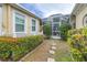 Manicured backyard featuring lush greenery, stone pavers and a screened-in patio at 511 Winterside Dr, Apollo Beach, FL 33572