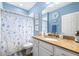 Bathroom with seashell-themed shower curtain, granite countertop, and light blue walls at 511 Winterside Dr, Apollo Beach, FL 33572