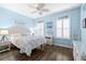 A serene coastal-themed bedroom has light blue walls, plantation shutters, and wood-look floors at 511 Winterside Dr, Apollo Beach, FL 33572