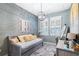 Cozy bedroom with a daybed, desk, wood accent wall, and modern light fixture at 511 Winterside Dr, Apollo Beach, FL 33572