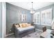 Cozy bedroom with a daybed, desk, wood accent wall, and modern light fixture at 511 Winterside Dr, Apollo Beach, FL 33572