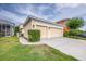 Exterior of a yellow home with a two-car garage and well-kept landscaping at 511 Winterside Dr, Apollo Beach, FL 33572
