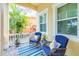 Cozy front porch featuring comfortable blue rocking chairs, a striped rug, and charming outdoor decor at 511 Winterside Dr, Apollo Beach, FL 33572