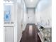 Hallway with wooden floor leading to a full bathroom, and white doors against light blue walls at 511 Winterside Dr, Apollo Beach, FL 33572