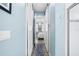 Light blue hallway features a view into a bedroom with an elegant chandelier at 511 Winterside Dr, Apollo Beach, FL 33572