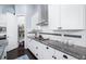 Well-equipped kitchen featuring white cabinets, granite countertops, stainless steel appliances, and a pantry door at 511 Winterside Dr, Apollo Beach, FL 33572