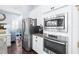 White cabinets, stainless steel appliances including a microwave and oven, plus a view of the living area at 511 Winterside Dr, Apollo Beach, FL 33572