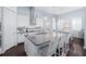 Modern kitchen featuring a large island with seating, white cabinetry, and stainless steel appliances, ideal for cooking at 511 Winterside Dr, Apollo Beach, FL 33572