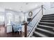 Cozy living area with a round mirror, plantation shutters, and adjacent staircase with gray carpet treads at 511 Winterside Dr, Apollo Beach, FL 33572