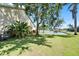 Large grassy backyard featuring mature trees and a waterfront view with a dock and waterway at 5205 Brighton Shore Dr, Apollo Beach, FL 33572