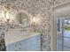 Stylish bathroom with patterned wallpaper, unique lighting, and a modern vanity at 5205 Brighton Shore Dr, Apollo Beach, FL 33572