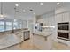 Bright kitchen featuring white cabinets, stainless steel appliances, an island, and a view to the outside at 5205 Brighton Shore Dr, Apollo Beach, FL 33572