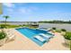 Backyard oasis featuring a private pool, in-pool loungers, a hot tub, and a dock on the water at 5205 Brighton Shore Dr, Apollo Beach, FL 33572