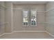 Spacious walk-in closet with carpeted floor, two windows with shutters, and wire shelving on multiple levels at 5205 Brighton Shore Dr, Apollo Beach, FL 33572