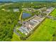 Aerial view features homes near a pond, set against a backdrop of lush trees and green fields at 5410 River Sound Ter, Bradenton, FL 34208