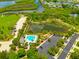 Aerial view of the community pool, playground, and pond surrounded by lush greenery at 5410 River Sound Ter, Bradenton, FL 34208