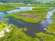Aerial view of a winding river through natural wetlands and a few houses at 5410 River Sound Ter, Bradenton, FL 34208