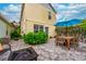 Paver patio backyard with table, umbrella, firepit, exterior lights, and landscaping at 5410 River Sound Ter, Bradenton, FL 34208