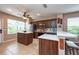 Well-lit kitchen featuring modern appliances, wooden cabinetry, a breakfast bar, and tile flooring at 5410 River Sound Ter, Bradenton, FL 34208