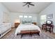 Bright bedroom with a large bed, ceiling fan, and a cozy sitting area at 5410 River Sound Ter, Bradenton, FL 34208