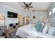 Bright main bedroom featuring white walls, ceiling fan, mounted TV, and doorway to Bedroom at 5410 River Sound Ter, Bradenton, FL 34208