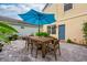 Outdoor patio furnished with a table, chairs, an umbrella, and lovely landscaping for backyard dining at 5410 River Sound Ter, Bradenton, FL 34208