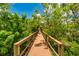 A wooden boardwalk meanders through lush foliage, inviting residents to explore the outdoors at 5410 River Sound Ter, Bradenton, FL 34208