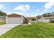 Charming single-story home with a well-maintained lawn, mature trees, and an attached two-car garage at 6370 Elmhurst Dr, Pinellas Park, FL 33782