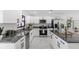 Contemporary kitchen featuring white cabinetry, granite countertops, stainless steel appliances, and modern finishes at 6370 Elmhurst Dr, Pinellas Park, FL 33782
