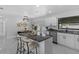 Modern, open-concept kitchen featuring granite countertops, island seating, and a connecting dining area at 6370 Elmhurst Dr, Pinellas Park, FL 33782