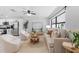 Bright living room featuring large windows, plush seating, a ceiling fan, and modern decor accents at 6370 Elmhurst Dr, Pinellas Park, FL 33782