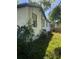 Exterior view of a white home with shrubbery, greenery, and an AC unit in the backyard at 6403 Elliot Dr, Tampa, FL 33615
