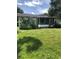 Exterior view of the home with overgrown front yard and front porch at 6403 Elliot Dr, Tampa, FL 33615