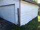 Exterior view of a garage with white siding next to a large door at 6403 Elliot Dr, Tampa, FL 33615